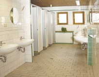 Waschraum mit Waschbecken und Einzelwaschkabinen