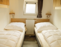 Schlafzimmer zwei mit zwei Einzelbetten im Chalet Lugge am Campingplatz Stein am Simssee