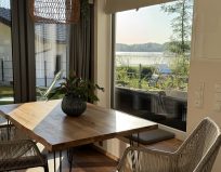 Chalet Leni - Wohnraum mit Sofa, Fernseher, Essbereich und Küche mit Kühlschrank, Spülmaschine und Mikrowelle